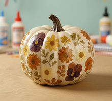 a ceramic pumpkin painted with dried pressed flowers mod podged on it